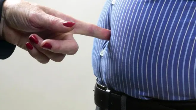 Палец упирается в живот толстяка