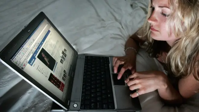 Mujer joven usando Facebook