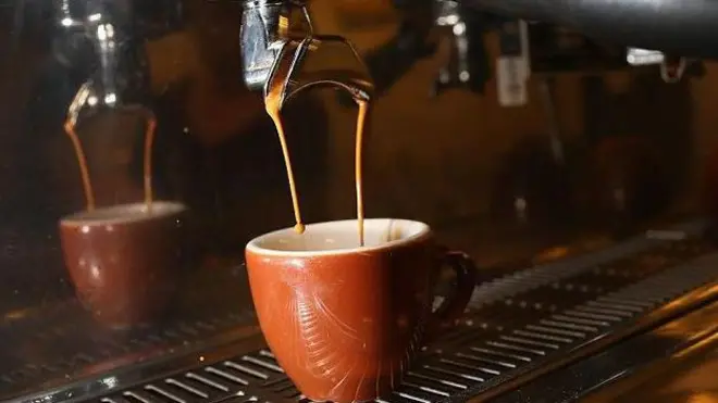 قهوة تنزل من ماكينة صنع قهوة في فنجان