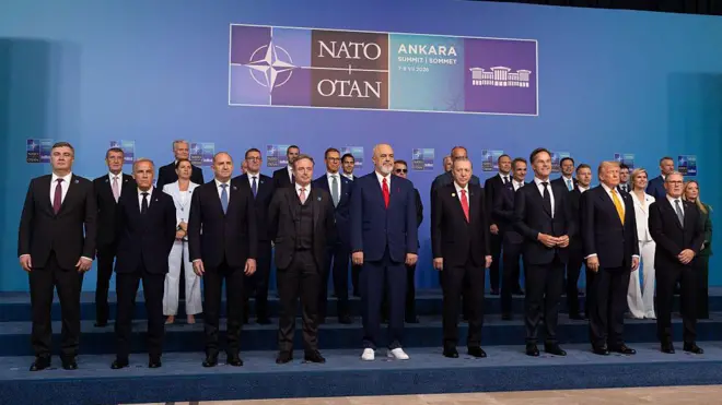 NATO ülkelerinin liderleri üç katlı bir podyumda yan yana duruyor