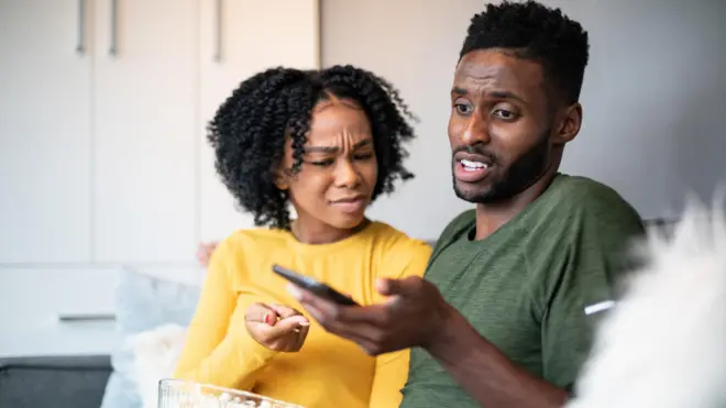 Umugabo n'umugore baraba muri telefone