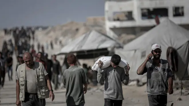 رجل فلسطيني يتسلم الطعام من نقطة توزيع مساعدات إنسانية في بيت لاهيا، شمال غزة، يوم الأحد 20 يوليو/تموز 2025. 