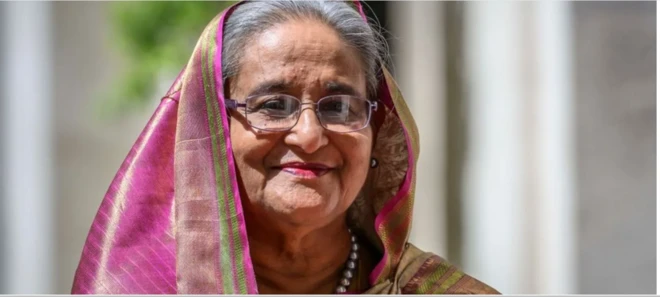 Older stateswoman in pink sari wearing glasses