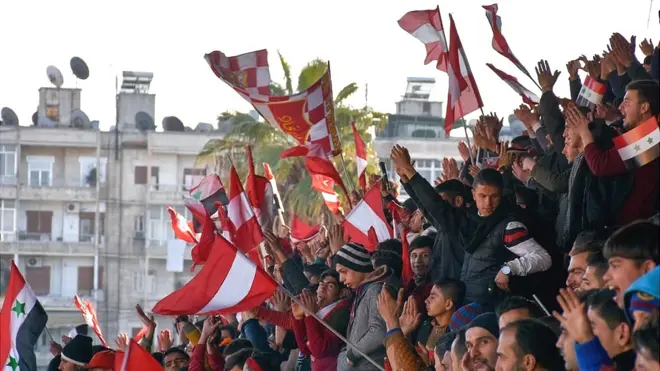 Al-Ittihad supporters wave red and white flags - their team's colours - from the stands