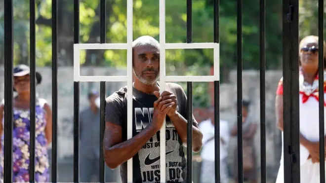 A man stands at the closed gate of a church in Port-au-Prince, Haiti, on Easter Sunday