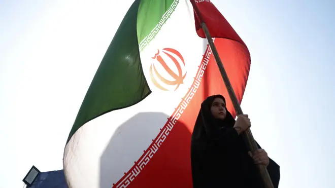 امرأة تحمل العلم الإيراني في أحد شوارع طهران، إيران، 10 يونيو/حزيران 2026. 
