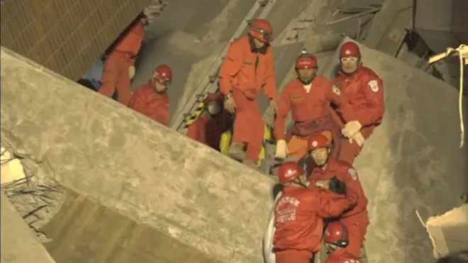 倒壊したマンションで救出作業