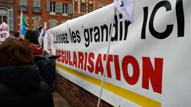 На баннере написано: оставьте их расти здесь. Урегулирование (статуса). В марте прошлого года в одном из городов Франции прошел митинг с требованием не высылать детей и их родителей, несмотря на отсутствие у них документов