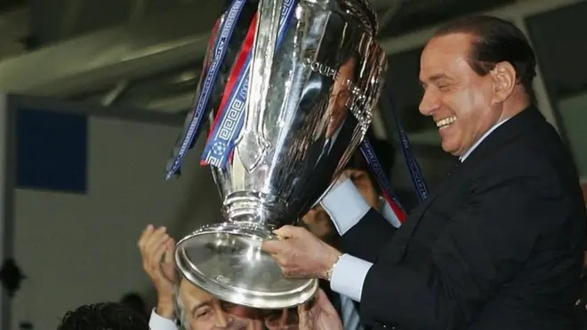 Silvio Berlusconi dengan tropi Liga Champions setelah anak asuhnya mengalahkan Liverpool pada 2011.