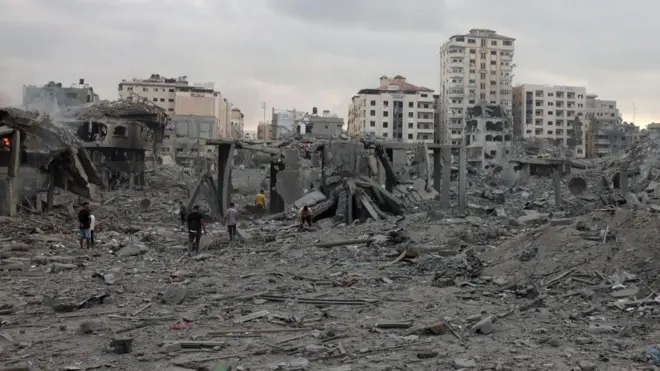 Palestinians inspect the destruction following Israeli airstrikes on Gaza City's al-Rimal district, early on October 10, 2023