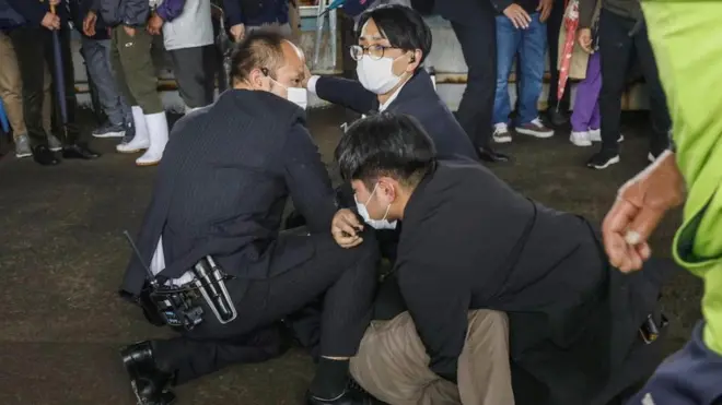 A man believed to be a suspect in the smoke-bomb throwing was held by police officers