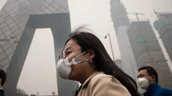 A man and a woman wear pollution masks in Beijing