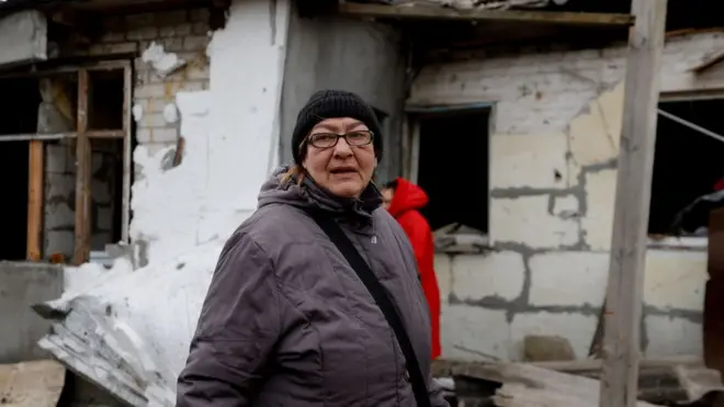 Жінка біля свого зруйнованого будинку в Дарницькому районі Києва