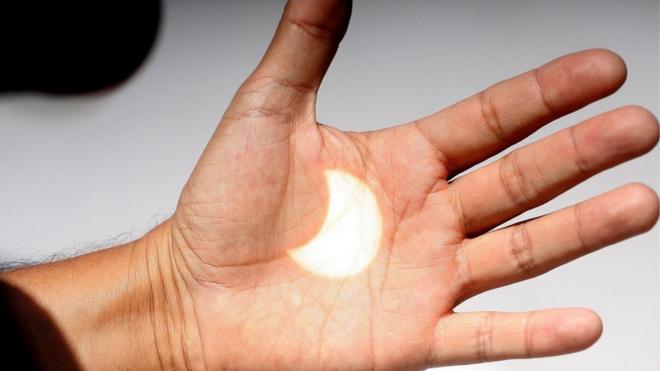 Una imagen del eclipse solar se proyecta sobre una mano en Ensenada, Baja California, México, 21 de agosto de 2017