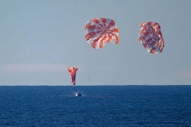 নভোচারীদের বহনকারী ক্যাপসুলটি প্রশান্ত মহাসাগরে অবতরণের দৃশ্য