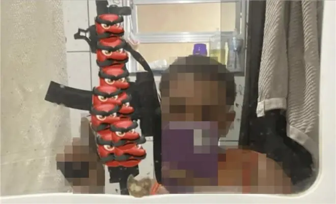 Um adolescente segura um fuzil em publicação em rede social