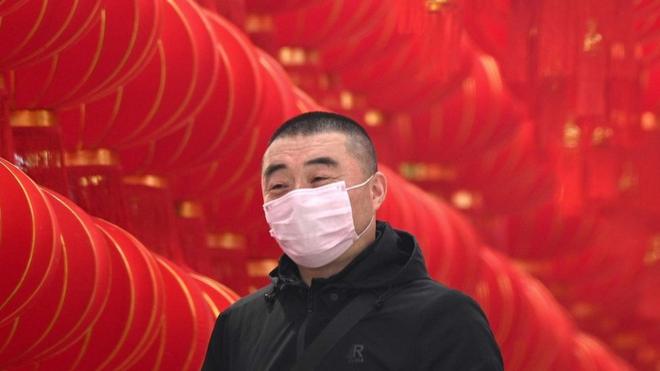 Un hombre en China usando una mascarilla.