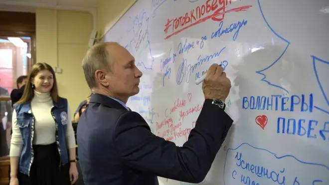 Владимир Путин в своем предвыборном штабе в Москве. Слева - руководитель "Волонтеров победы" Ольга Амельченкова