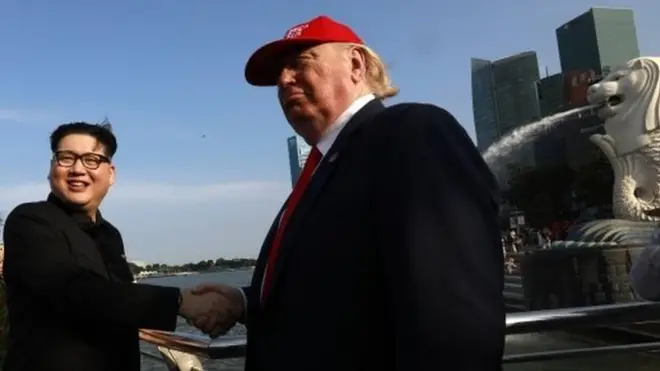 模仿朝鲜领导人金正恩和美国总统特朗普的霍华德X (C)和丹尼斯·阿兰6月8日在新加坡握手。
