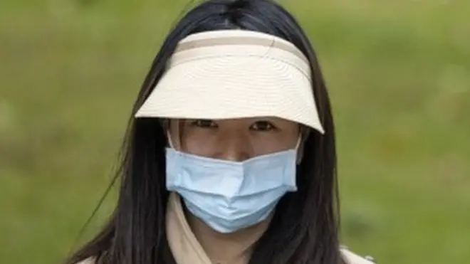 चीन में मास्क लगाई हुई एक महिला