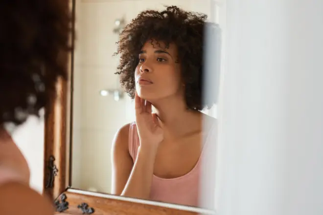 Woman starring at the mirror 
