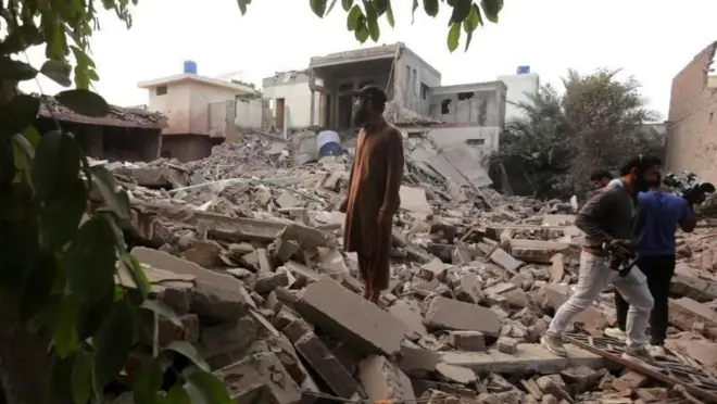 一名男子站在穆里德克一棟建築的廢墟上。