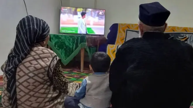 Телевизор қаршисида