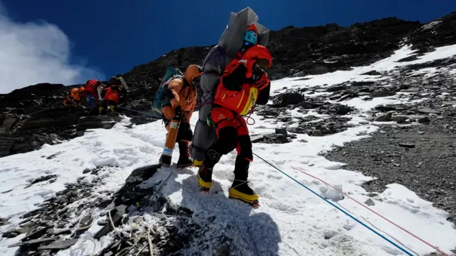 आरोहीको उद्धार गर्दै शेर्पाहरू। 