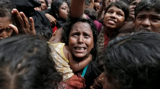 A woman reacts as Rohingya refugees wait to receive aid