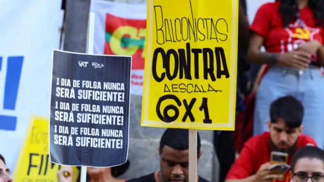 Trabalhadores seguram placas pelo fim da escala 6x1 e melhores condições de trabalho e renda, na Cinelândia, no centro da capital fluminense, em Ato do Dia do Trabalhador, em 2025.
