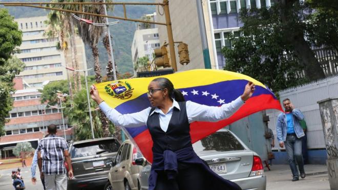 A woman holds a Venezuelan flag during a demonstration - 30 January 2019