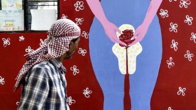 Un hombre en India camina frente a un mural que representa la menstruación en Guwahati, el 28 de mayo, 2019