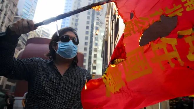 An anti-government protesters burns a commemorative banner in protest of National Day in Hong Kong, China, 01 October 2019