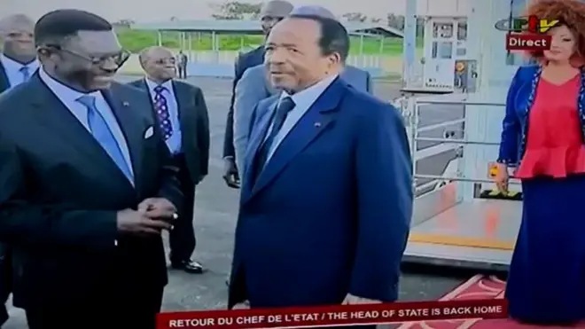 Screengrab from live television wey show as one official dey greet Paul Biya for di airport. Im wife, Chantal, show for di background.
