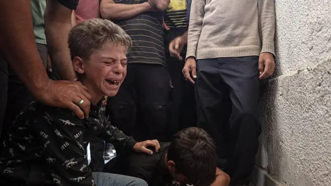 Dos niños lloran tras la muerte de un familiar que concurrió a buscar ayuda a uno de los puntos de distribución