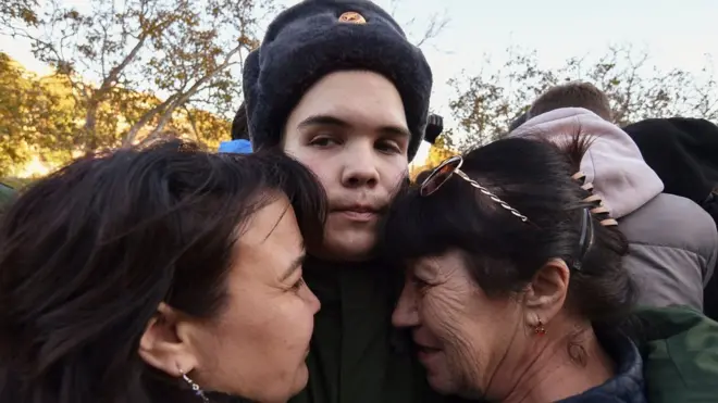 A Russian conscript bids farewell to his relatives before he leaves to serve in the army at a railway station in Sevastopol, Crimea