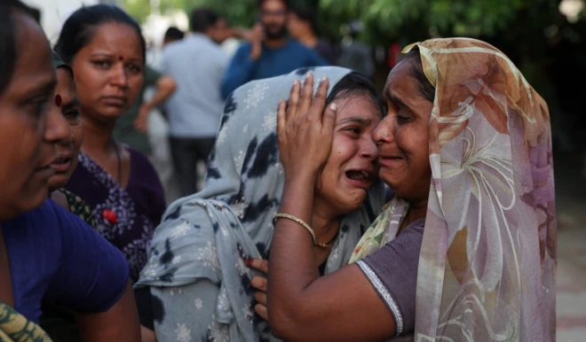 Air India uçağında kardeşini kaybeden bir kadın ağlıyor ve teselli edilmeye çalışılıyor.