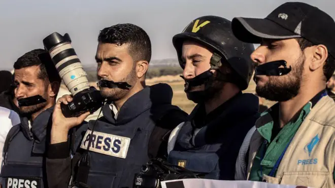 صحفيون فلسطينيون يغلقون أفواههم بشريط لاصق خلال احتجاج على مقتل زميلهم الصحفي ياسر مرتجى، في رفح بجنوب قطاع غزة، في 8 نيسان/أبريل 2018