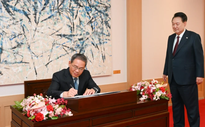 윤석열 대통령이 26일 용산 대통령실 청사에서 열린 한중 양자회담에 앞서 리창 중국 총리가 방명록을 작성하는 모습을 지켜보고 있다