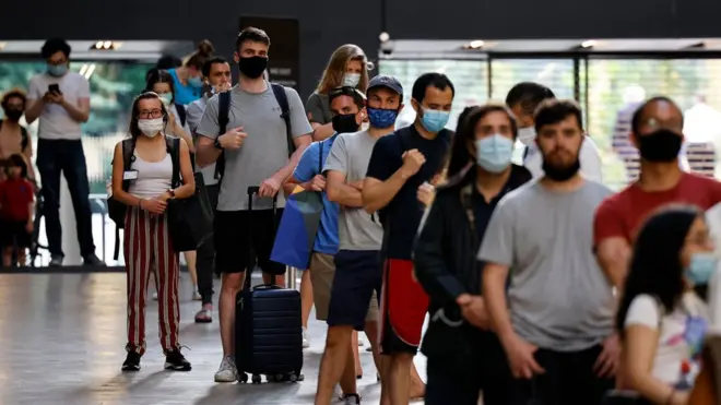 Members of the public queue to receive the Pfizer-BioNTech Covid-19 vaccine in the Turbine Hall at a temporary Covid-19 vaccine centre at the Tate Modern in central London on July 16, 2021