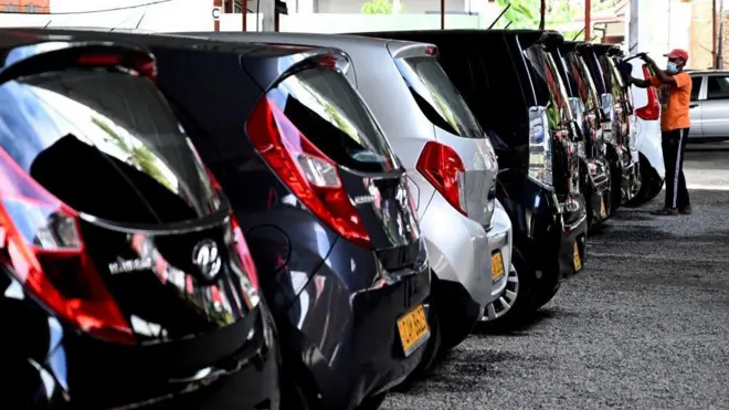 a man washes cars displayed for sale at a car dealership