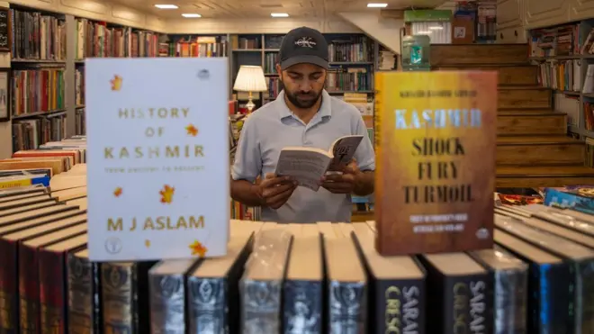 जम्मू-कश्मीर में एक किताब की दुकान में एक व्यक्ति किताब देख रहा है.
