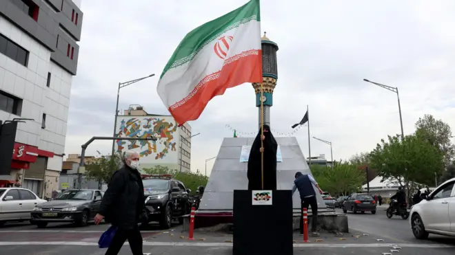 伊朗德黑蘭街頭一位身穿全身罩袍的女士揮舞國旗(12/4/2026)