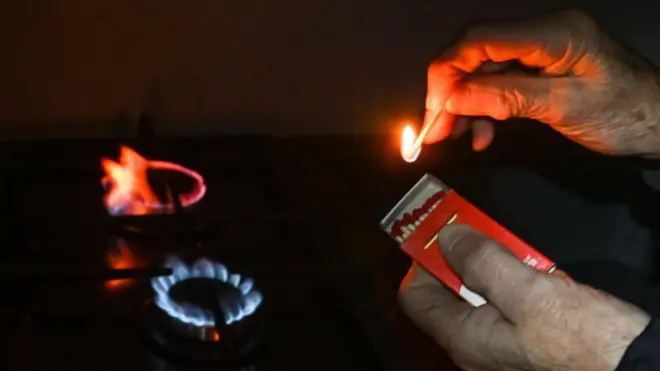 Людина запалює сірниками газову плиту 