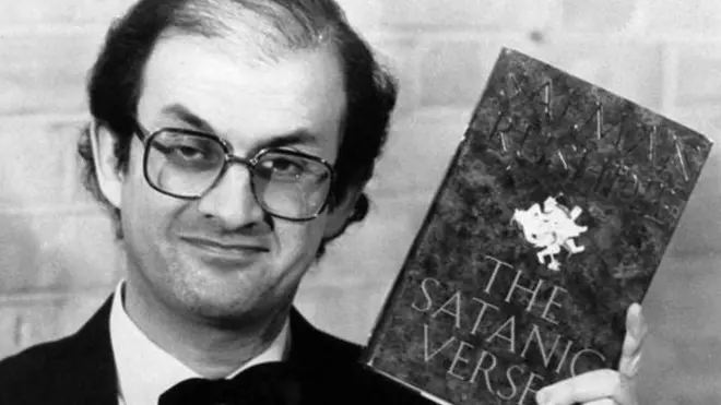 Salman Rushdie con su libro Los versos satánicos.