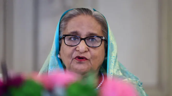 Шейх Хасина - пожилая седоватая женщина в очках и синем платке