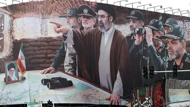 بیلبورد بزرگی از مجتبی خامنه‌ای و فرماندهانی که او را احاطه کرده‌اند، حامیان جمهوری اسلامی در خیابان تجمع کردند