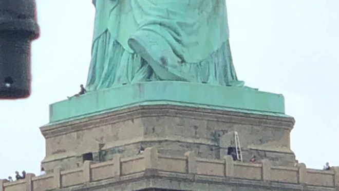 한 여성이 자유의 여신상의 대좌에 올라가 경찰과 3시간 반 정도 대치했다