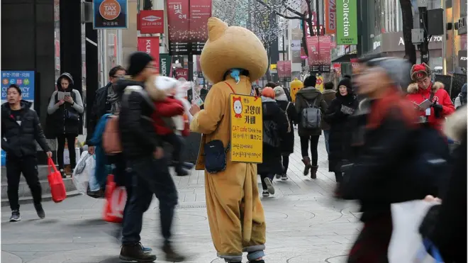 정부의 최저임금 결정체계 개편안 발표가 있었던 7일 오후 서울 명동거리에서 고양이 탈을 쓴 한 아르바이트생이 전단지를 나눠주고 있다