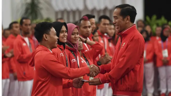 Presiden Joko Widodo (kanan) menyalami dan memberikan buku tabungan kepada lifter Eko Yuli Irawan (kiri) saat pemberian bonus kepada atlet peraih medali di Istana Negara, Jakarta, Minggu (2/9).